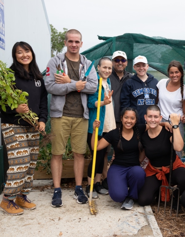A group of students and natives posing for the camera after working together on agricultural initiatives.